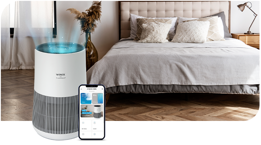 WINIX-PlasmaWave®-Technologie WINIX Luftreiniger mit Smartphone vor einem Bett